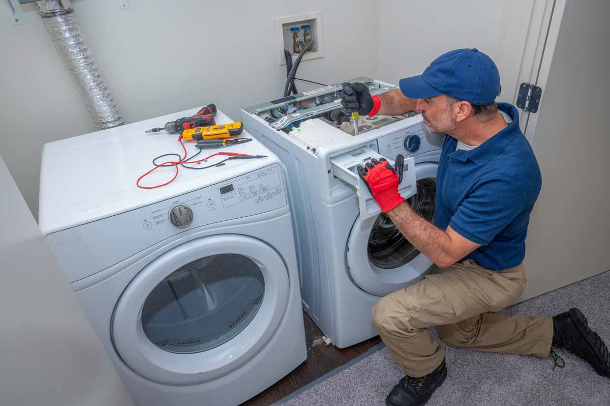Man repairs detergent drawer on washing machine