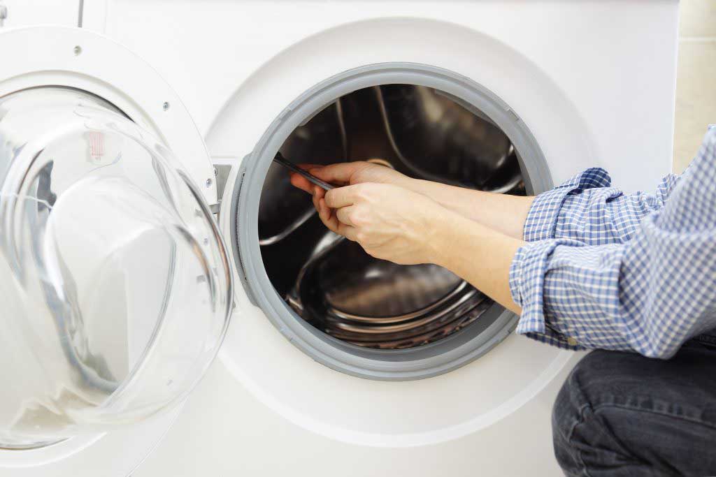 Man repairs a washing machine